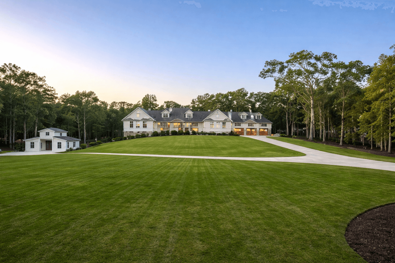 Milton estate home on expansive green pasture at dusk